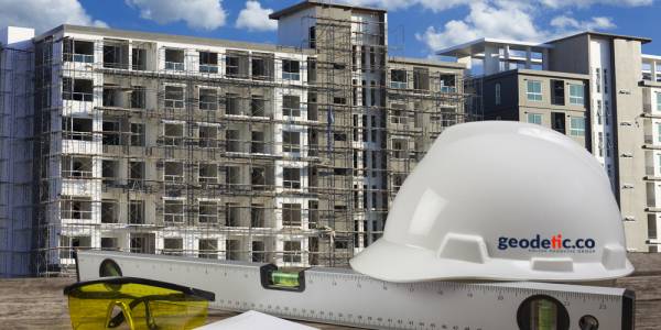 file of safety helmet and architect plant on wood table with blue sky scene and building construction